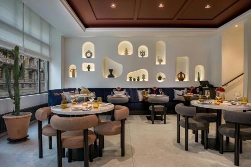 a restaurant with two tables and stools and chairs at Neues Schloss Privat Hotel Zurich, Autograph Collection in Zürich