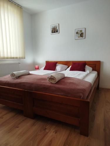 a bedroom with a large bed with white and red pillows at Guest House Kovalik in Suchá Hora