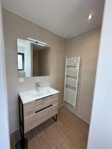 une salle de bain avec un lavabo et un miroir dans l'établissement Villa Dyane, à Salavas