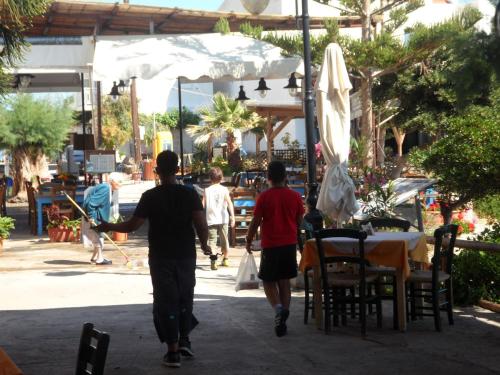 a group of three people walking down a sidewalk at Mochlos Beach Villa Seafront house in Mochlos