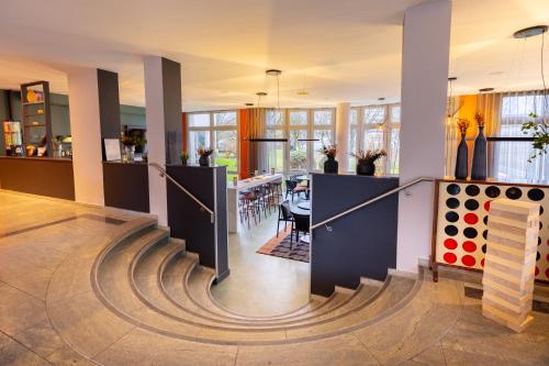 a hallway with a spiral staircase in a house at Holiday Inn - the niu, Blade Solingen by IHG in Solingen