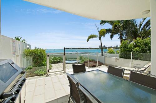 a patio area with chairs, tables, and a pool at Waves Maroochy River in Maroochydore