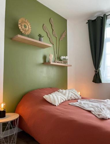 - une chambre avec un lit rouge et des étagères murales dans l'établissement Au spa de clem, à Guemps