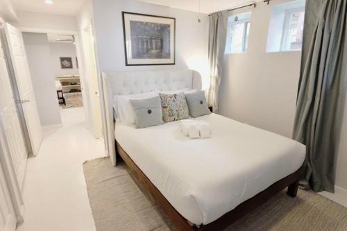 a bedroom with a large bed with white sheets and pillows at 16th St Heights Family Haven in Washington, D.C.