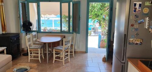 a kitchen with a table and chairs and a door at Mochlos Beach Villa Seafront house in Mochlos