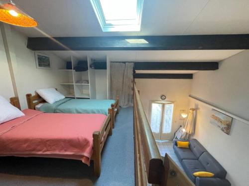 une petite chambre avec deux lits et un canapé dans l'établissement Maison 2 pièces avec mezzanine - Argelès-sur-Mer AR150-013, à Argelès-sur-Mer