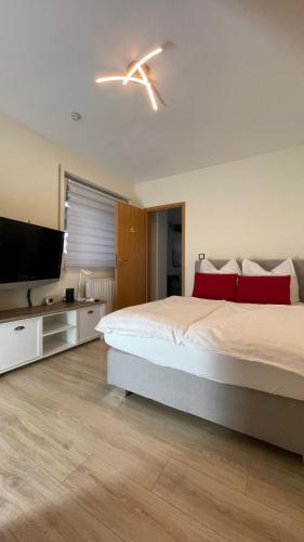 a bedroom with a large bed and a flat screen tv at Hemerhardt Suite in Hemer