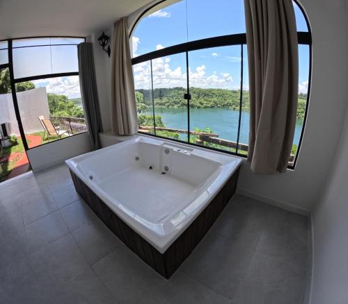 a large bath tub in a bathroom with large windows at Hotel Casablanca Boutique Ciudad del Este By Swiss Bonmont Hotels in Ciudad del Este