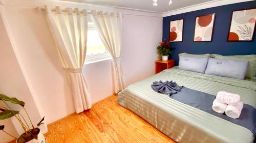 a bedroom with a bed with blue walls and a window at Lê Mùi Hotel - Apartment in Da Thien