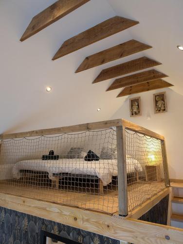 - une chambre avec un lit dans une pièce dotée de poutres apparentes dans l'établissement Gîte Les Hortensias Les Jardins de Kerellec 20min de la mer jacuzzi et terrasse, à Plouvorn