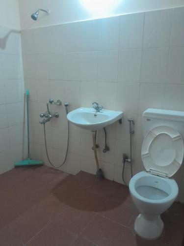 a bathroom with a toilet and a sink at Travellers Homestay in Silchar