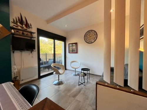 - un salon avec des chaises et une horloge murale dans l'établissement La Cabane de la Dune ~ Au bord de l'Océan, à Mimizan