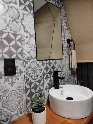 bagno con lavandino bianco e specchio di Ayün Lodge a Pucón