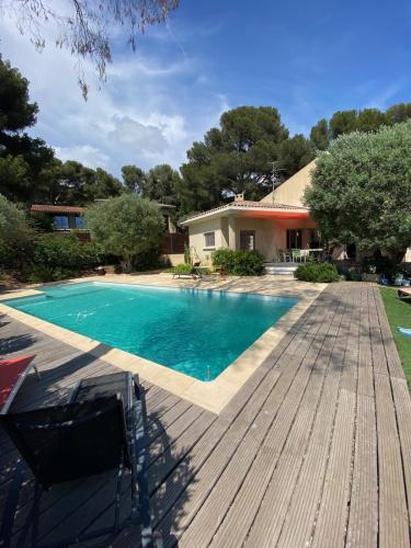 une piscine sur une terrasse à côté d'une maison dans l'établissement Villa - 6 pers - 3 chambres - Piscine - Climatisations, à Sanary-sur-Mer
