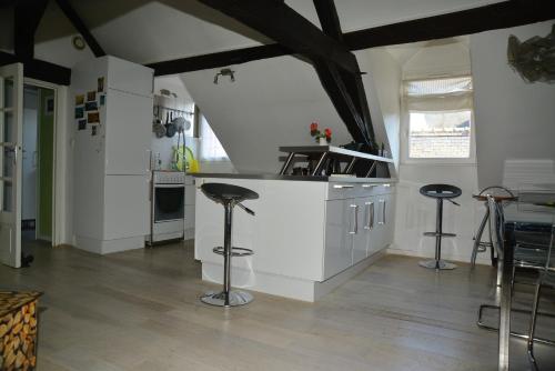 une cuisine avec un comptoir blanc et des tabourets dans l'établissement Tours hypercentre - Vieux Tours, à Tours