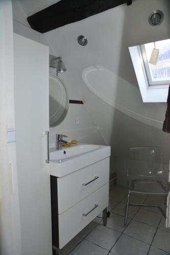 une salle de bain avec un lavabo, un miroir et une chaise dans l'établissement Tours hypercentre - Vieux Tours, à Tours