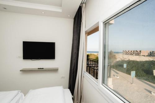 a bedroom with a large window with a view of the ocean at Selina Bay Resort in El Gouna