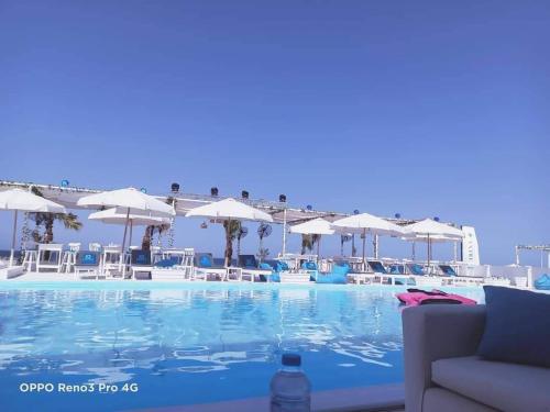 a large swimming pool with chairs and umbrellas at Selina Bay Resort in El Gouna