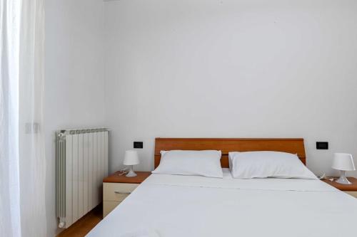a bedroom with a large white bed and two lamps at Casa Pierina - Lake View - by Host4U in Costa Volpino