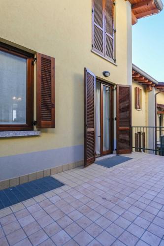 a house with wooden doors and a balcony at Casa Pierina - Lake View - by Host4U in Costa Volpino