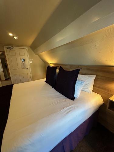 a bedroom with a large white bed with black pillows at The Chocolate Box Guest House in Bournemouth