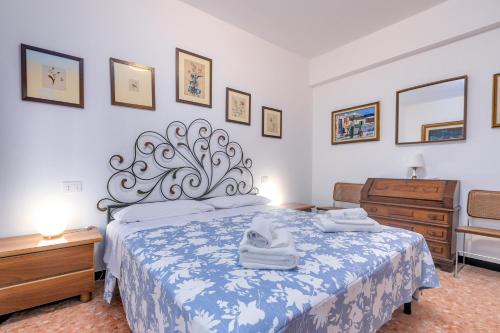 a bedroom with a bed with a blue and white bedspread at 287 - Casa Dede a Deiva Marina - 300metri dal Mare e dal Centro Storico in Deiva Marina