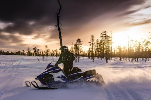 a man is riding a snowmobile in the snow at Log cabin with HOT TUB and view in La Minerve