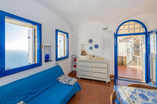 a bedroom with a blue bed and a window at Casa Maiolica in Finale Ligure
