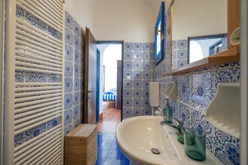 a blue and white bathroom with a sink and a mirror at Casa Maiolica in Finale Ligure