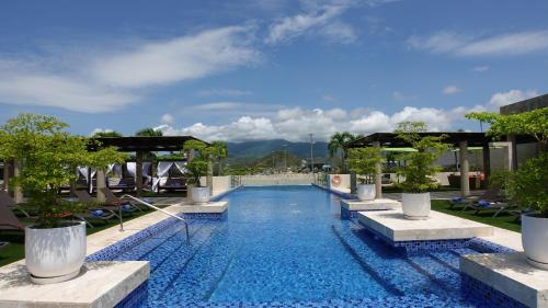 a pool at a hotel with trees and chairs at SUNSOL UNIK Luxury Hotel in Porlamar