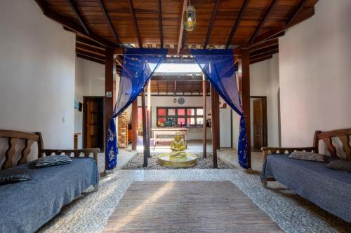 two beds in a room with blue drapes at House da Lui in Ubatuba