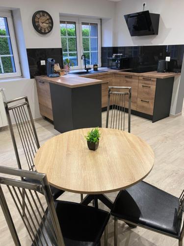 une cuisine avec une table et des chaises en bois dans l'établissement Marilyn guest room, à Bisten-en-Lorraine