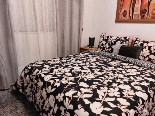 a bedroom with a bed with a black and white blanket at Appartement avec terrasse au cœur du centre-ville de Rabat in Rabat