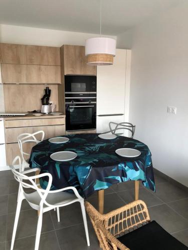 a kitchen with a table and two chairs and a kitchen with a kitchen at Henea in Saint-Paul-lès-Dax