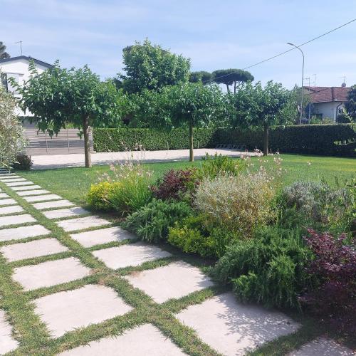 a garden with a stone pathway in a park at Slowersilia Bed and Breakfast in Lido di Camaiore