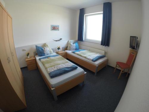 a hotel room with two beds and a window at Pension Take Off in Gera
