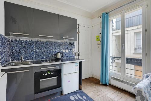 une cuisine avec un évier et une cuisinière four supérieur dans l'établissement PARIS 5 - Cosy appartement, à Paris