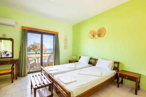 a bedroom with a bed and a desk and a window at Sun Beach Apartments in Karpathos Town