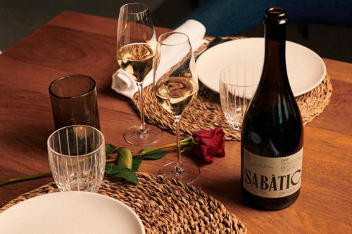 a table with a bottle of wine and glasses on it at Sabàtic Sitges Hotel, Autograph Collection in Sitges