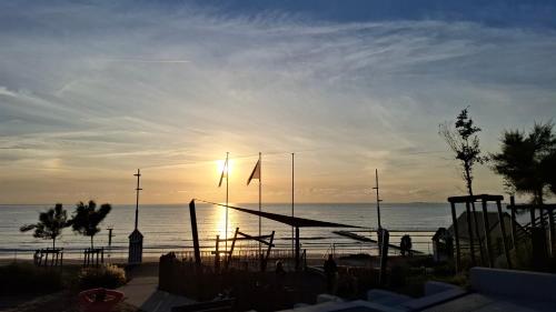 - un coucher de soleil sur la plage avec l'océan en arrière-plan dans l'établissement Chambre d'hôtes Nova, petit déjeuner compris, à Saint-Pair-sur-Mer