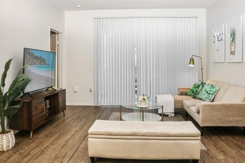 ein Wohnzimmer mit Sofa und Fernseher in der Unterkunft Luxe Marina Del Rey Apartment,Parking, Gym, Pool, jacuzzi,BBQ in Los Angeles