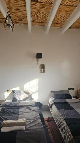 a bedroom with two beds and a ceiling at Tizi Maison d'Hôtes in Telouet