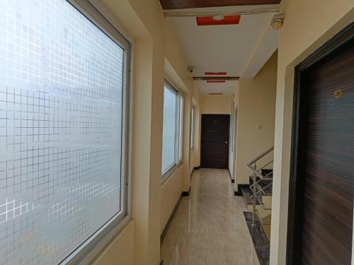 a hallway with a large window in a building at Golden Larch Comfort in Ooty