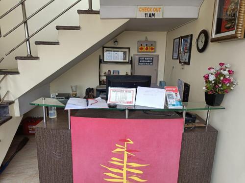 a reception desk in a building with a staircase at Golden Larch Comfort in Ooty