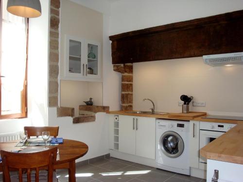 une cuisine avec une table et une machine à laver dans l'établissement Beaulieu Apartments, à Beaulieu-sur-Dordogne
