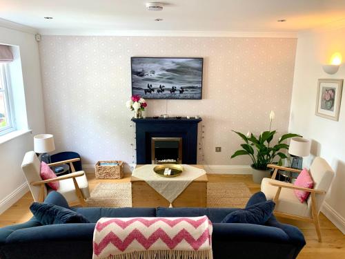 a living room with a blue couch and a fireplace at Goring Holiday House in Goring