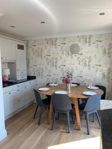 a dining room with a wooden table and chairs at Goring Holiday House in Goring
