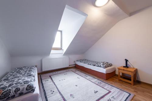 a attic bedroom with two beds and a rug at Apartment Vila Marianna in Vysoké Tatry