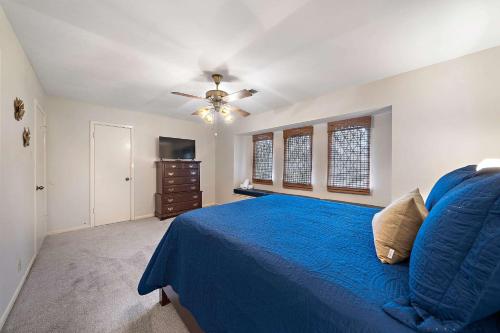 a bedroom with a blue bed and a ceiling fan at Relax and Play 3BR Retreat w Sunroom in Baytown