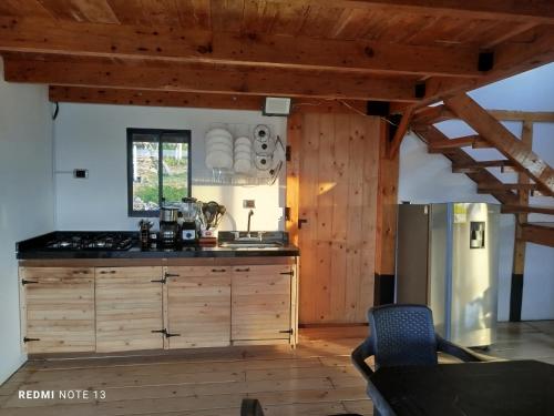 a kitchen with wooden cabinets and a counter top at San Luis Cabaña in Curití